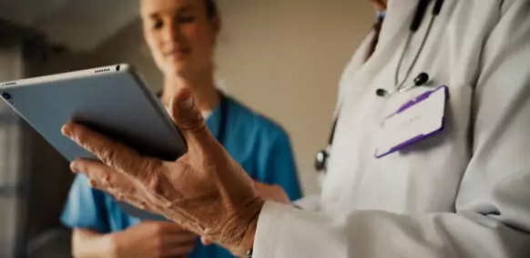 Close,Up,Of,Male,Doctor,Holding,Digital,Tablet,While,Female