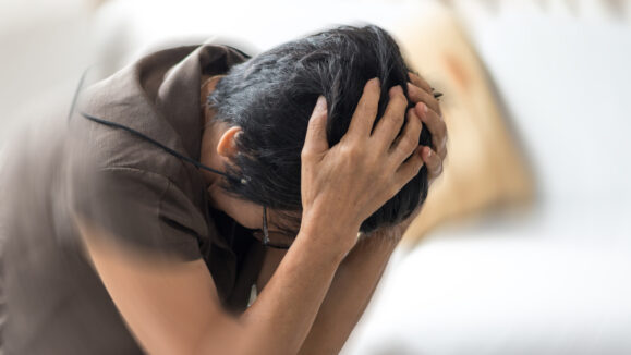 Vertigo illness concept. Old woman hands on her head felling headache dizzy sense of spinning dizziness,a problem with the inner ear, brain, or sensory nerve pathway.