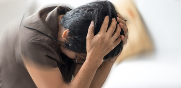 Vertigo illness concept. Old woman hands on her head felling headache dizzy sense of spinning dizziness,a problem with the inner ear, brain, or sensory nerve pathway.
