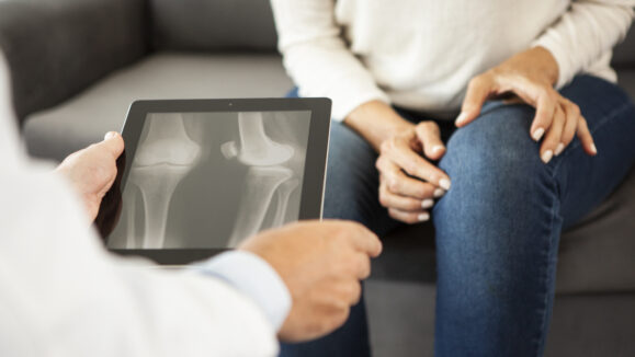 Close-up of doctor looking at X-ray on digital tablet