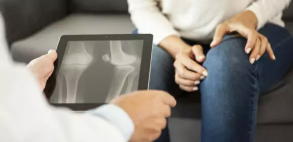 Close-up of doctor looking at X-ray on digital tablet