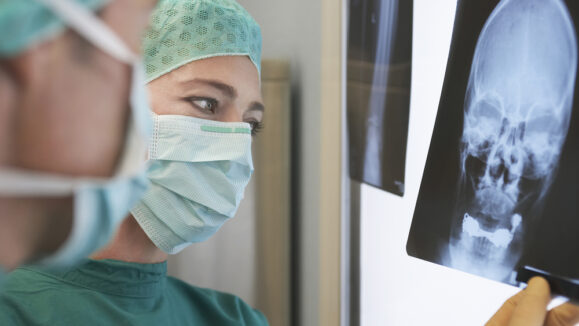 Closeup,Of,Two,Radiologists,Examining,Xray,Of,Skull