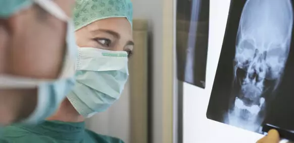 Closeup,Of,Two,Radiologists,Examining,Xray,Of,Skull